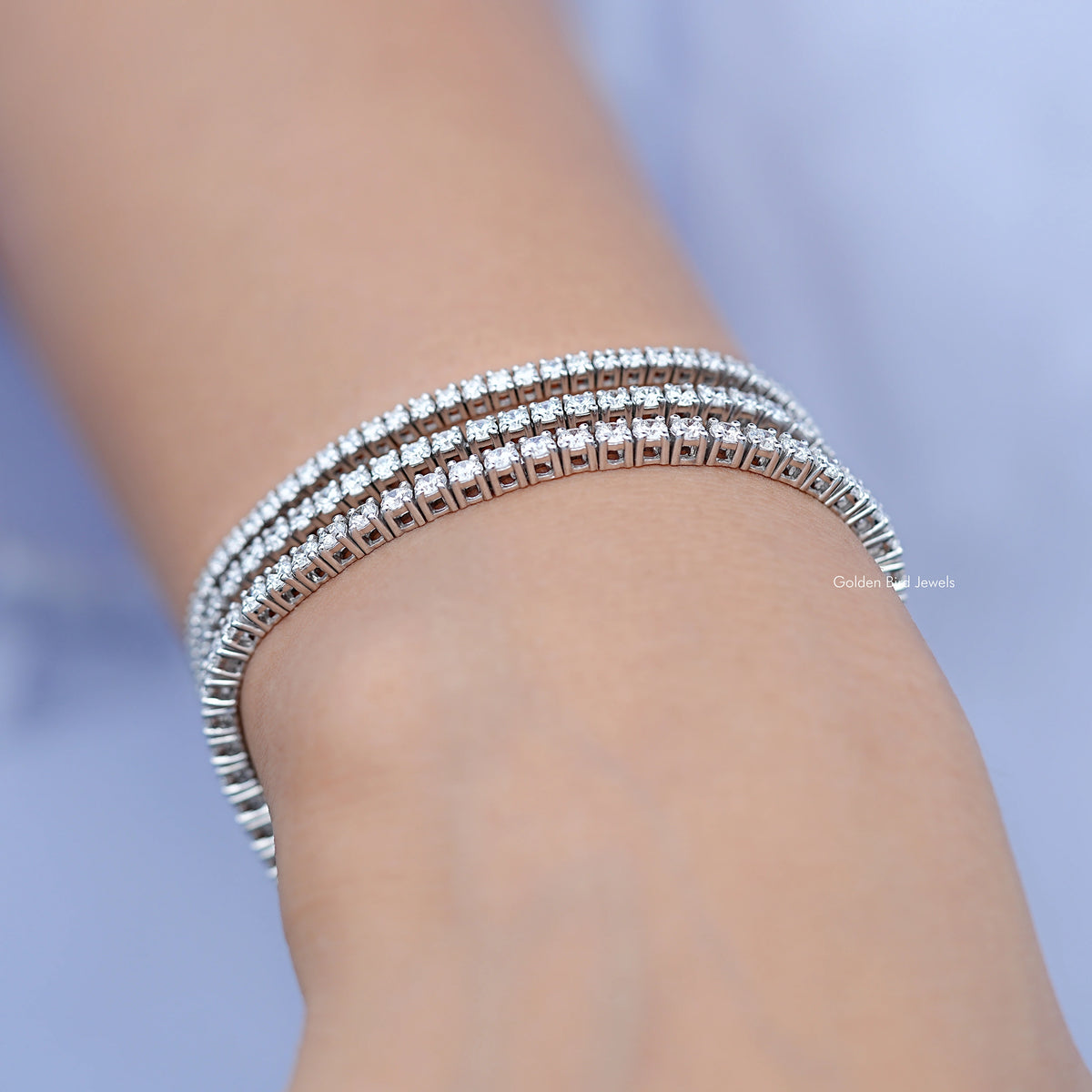 Close-up of silver tennis bracelet with round diamond stones around wrist