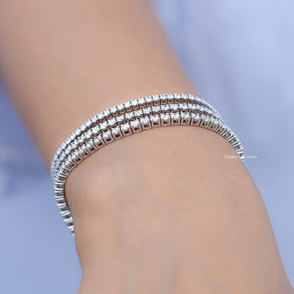 Close-up of silver tennis bracelet with round diamond stones around wrist