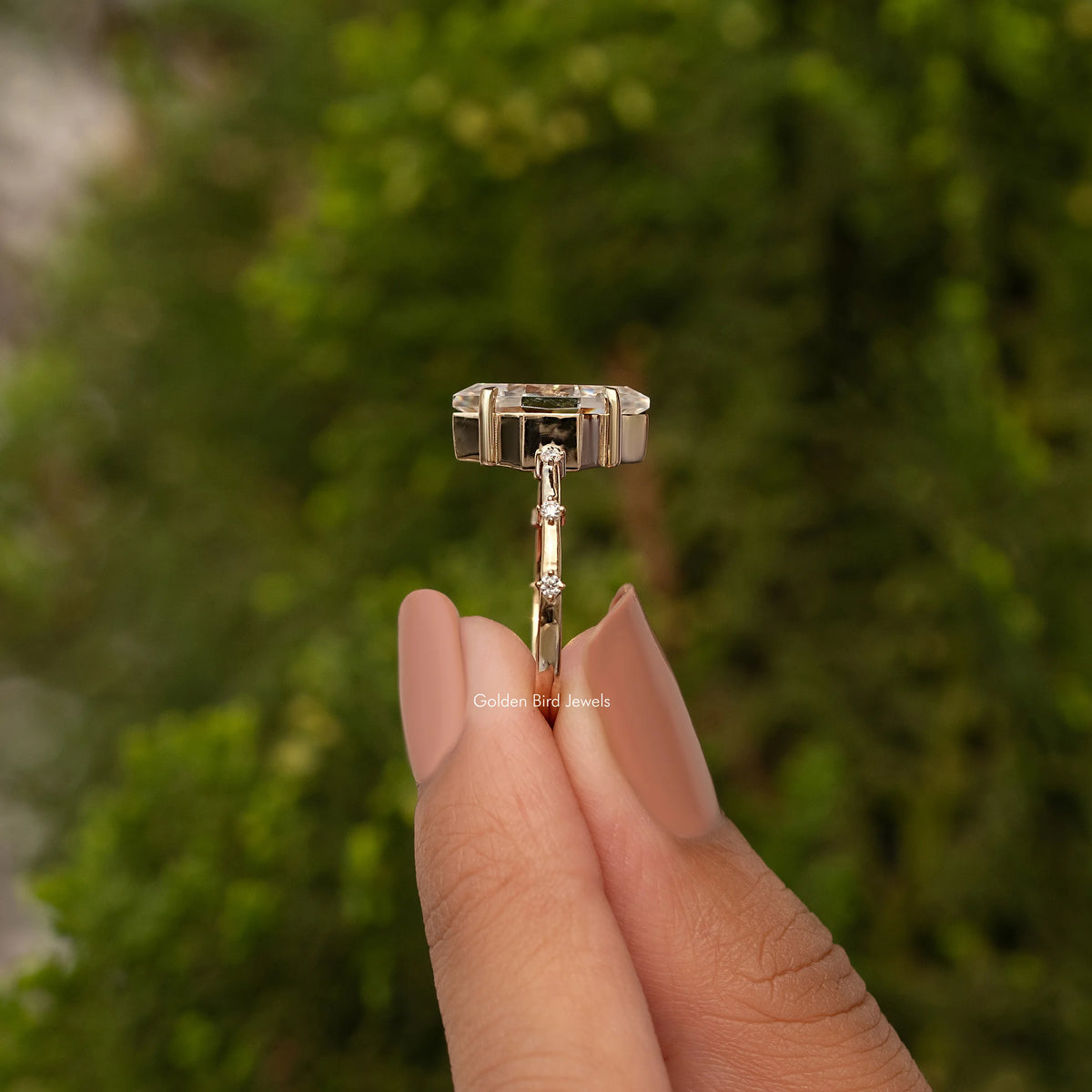 Gold-tone marquise moissanite ring top view with rectangular prongs and center stone