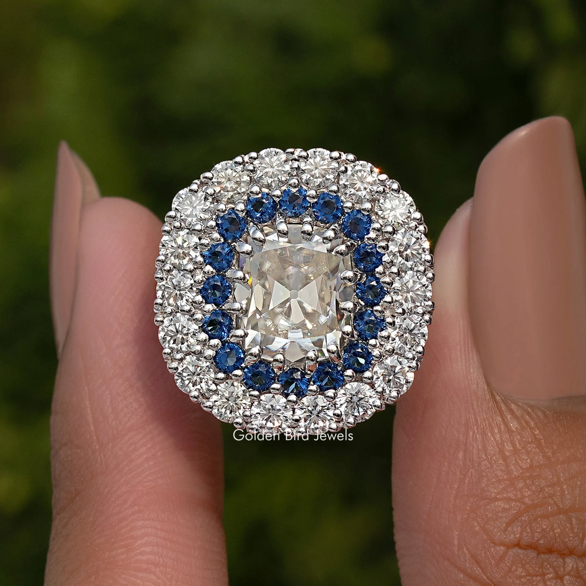Double halo cushion moissanite ring with blue inner stones and prong-set center