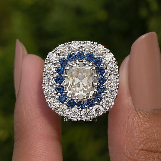 Double halo cushion moissanite ring with blue inner stones and prong-set center