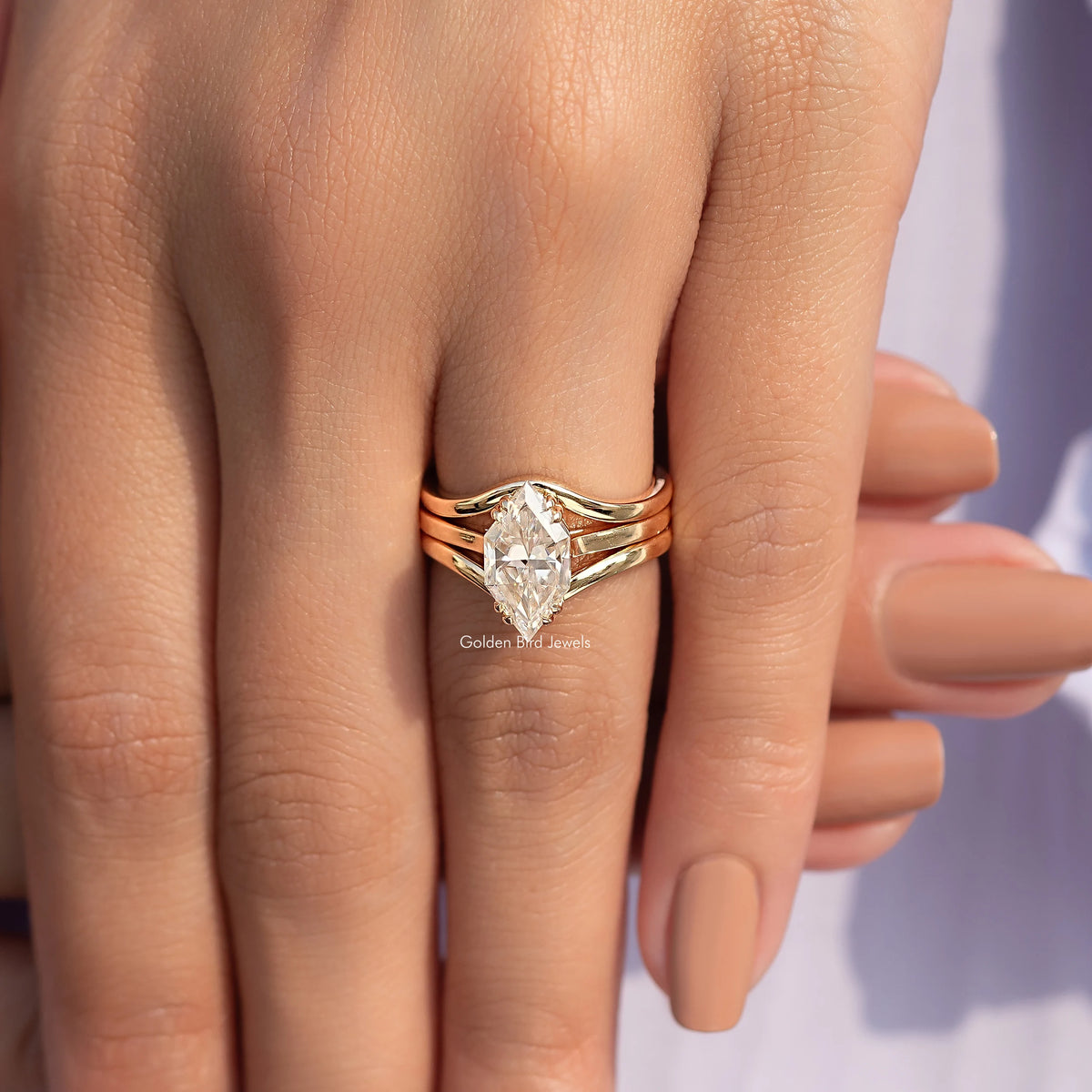 Gold tone engagement ring with large center stone and stacked side bands