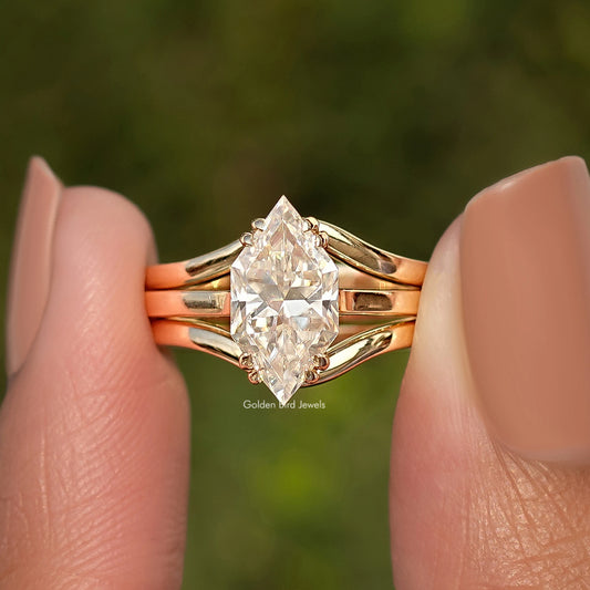 Gold tone engagement ring with large center stone, halo detail, and V-shaped prongs