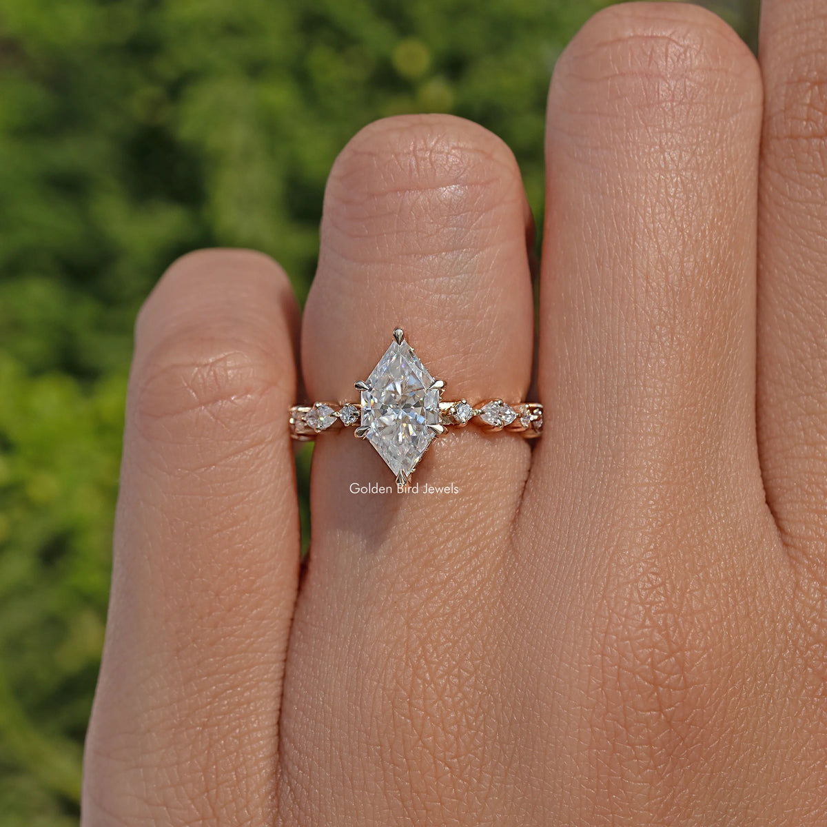 Gold-tone marquise moissanite ring with clustered round side stones on a slim band