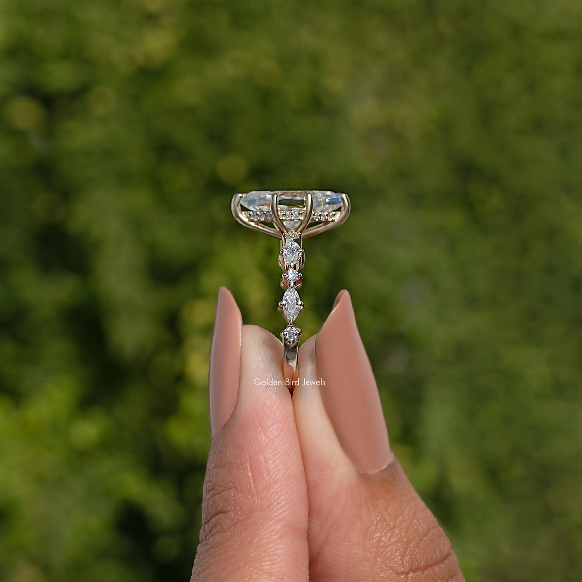 Gold-tone ring showing tall prong setting and marquise moissanite center stone