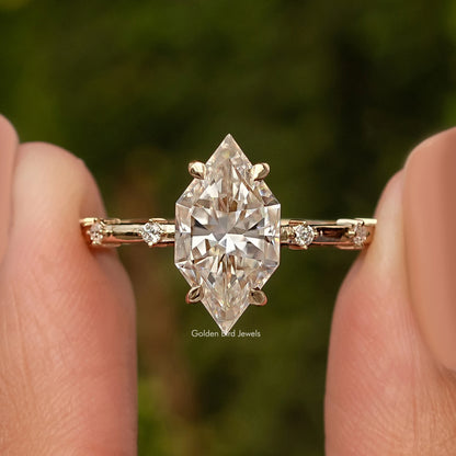 Gold-tone marquise moissanite ring close-up, center marquise stone with side accents