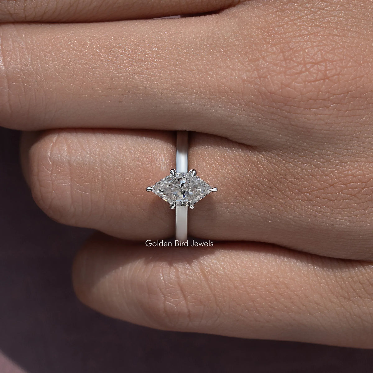Marquise-cut moissanite ring close-up on finger, silver band, side angle