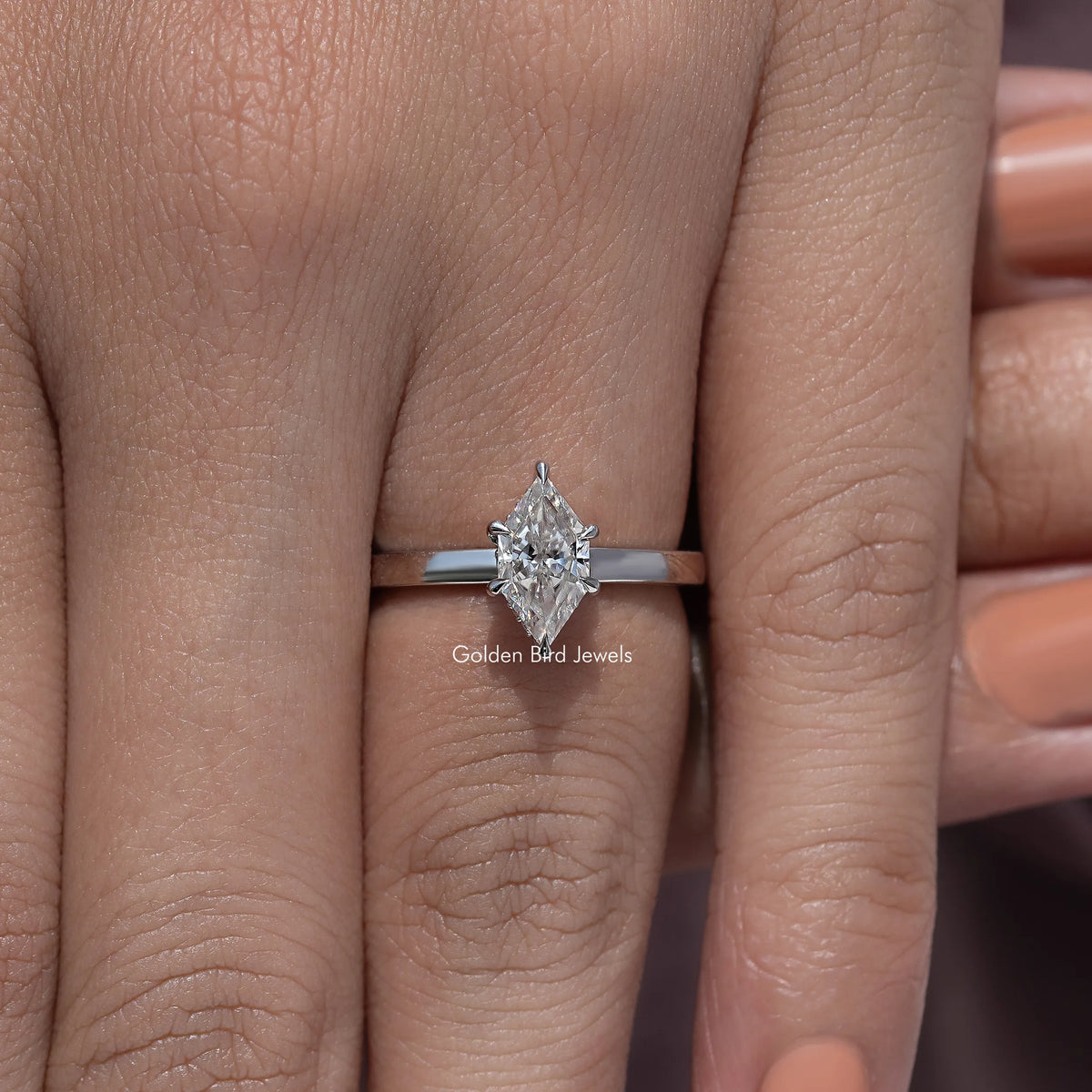 Marquise-cut moissanite ring on finger, silver band, centered stone view