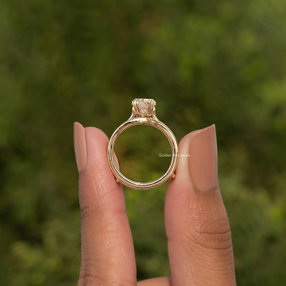 Gold tone ring with large round center stone and halo-like bezel top
