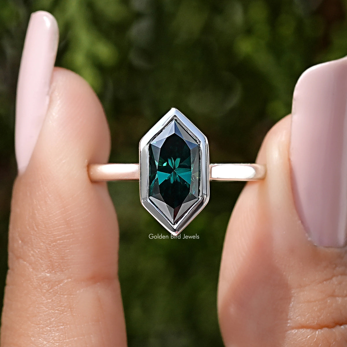 Sterling silver ring close-up: bezel-set emerald green marquise gemstone