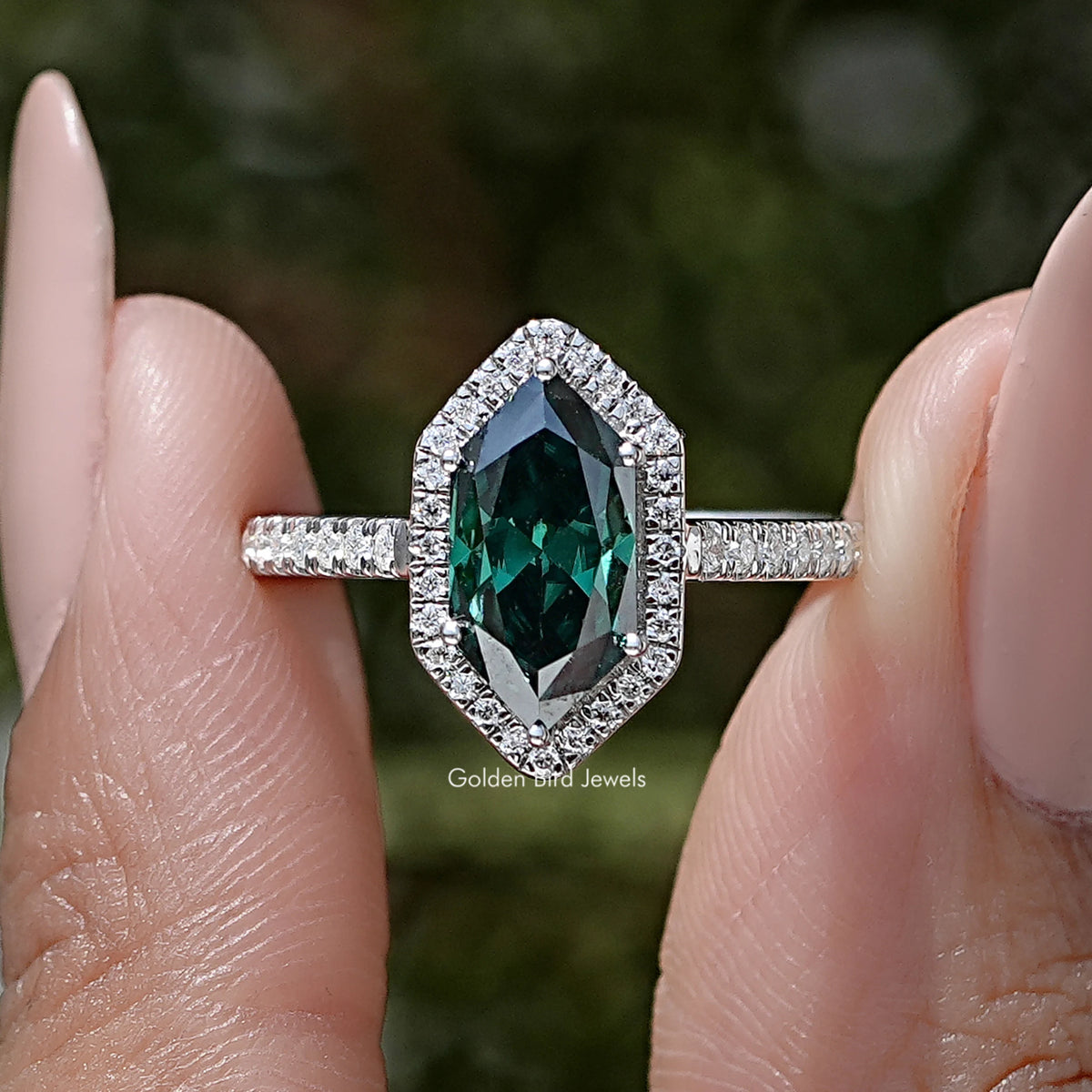 Sterling silver marquise halo accent ring close-up with green oval center and halo