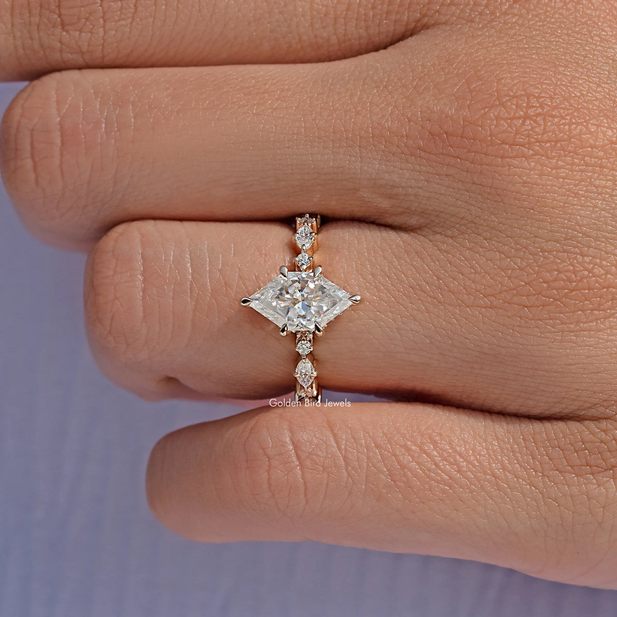 Gold-tone marquise moissanite ring with petite side stones, close-up view