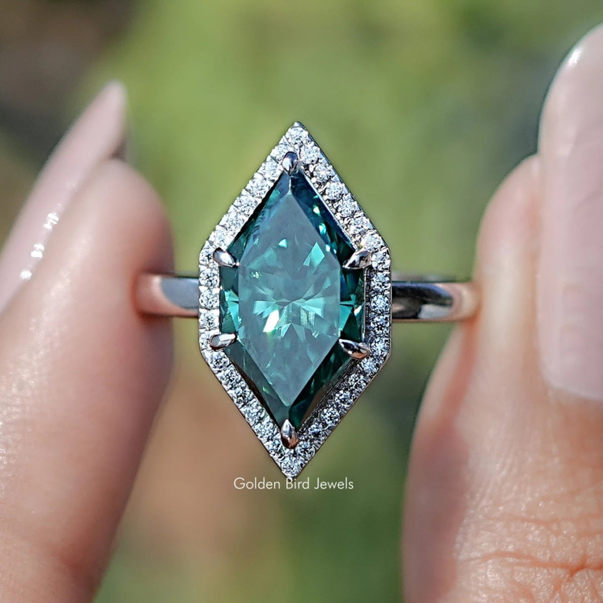 Teal marquise halo engagement ring with rectangular center stone, close-up frontal