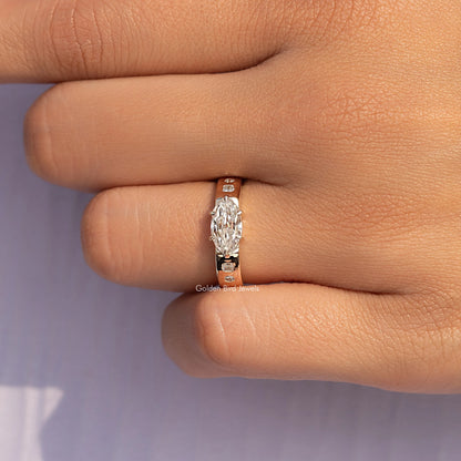 East-west oval moissanite accent ring in rose gold on finger