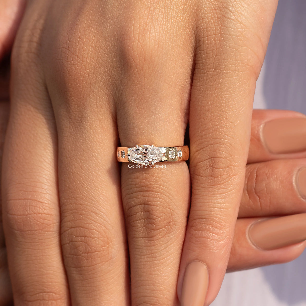 Gold moissanite accent ring with small stones along the band, close-up