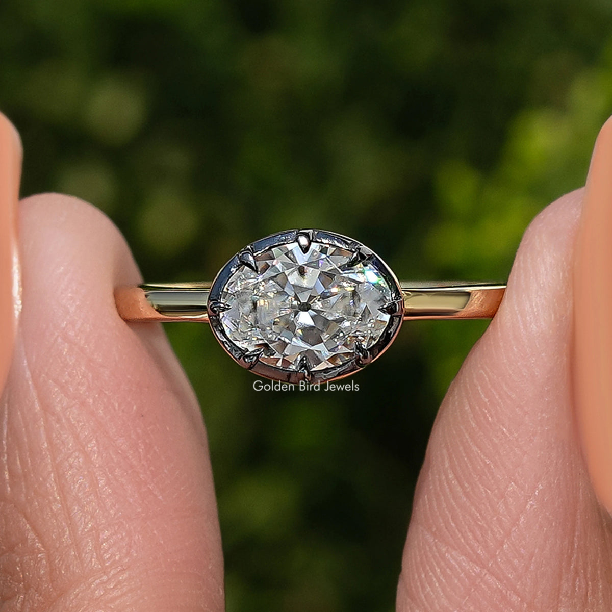 Gold oval-cut moissanite solitaire ring with faceted oval center stone close-up