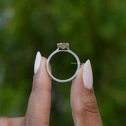 Emerald-cut yellow solitaire ring on silver-tone band, top view