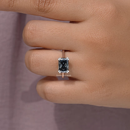 Silver solitaire engagement ring with square black gemstone, close-up on finger