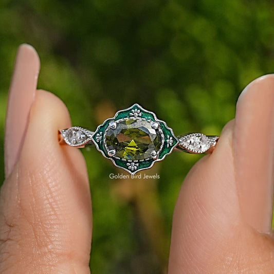 Oval green gemstone engagement ring with diamond halo and prong-set side stones