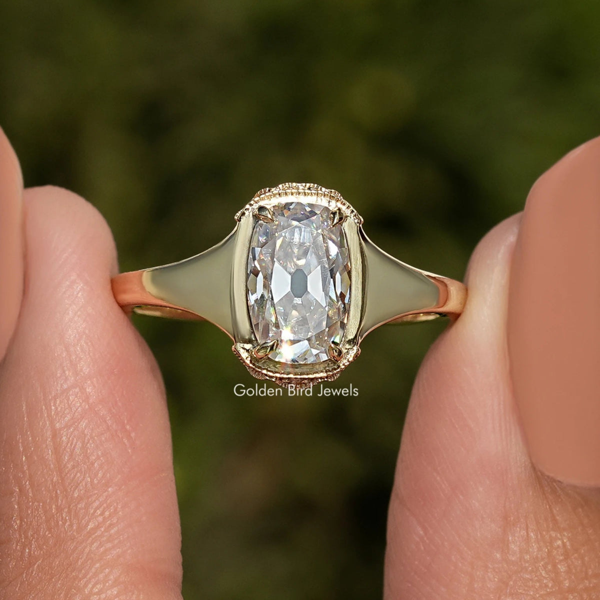 Elongated cushion-cut moissanite ring with gold-toned band and halo setting