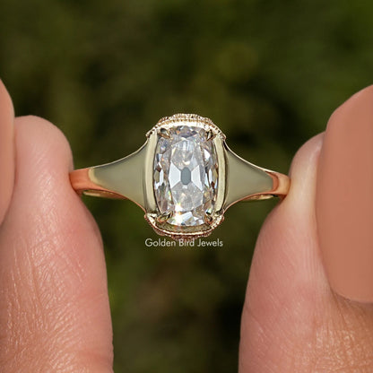 Elongated cushion-cut moissanite ring with gold-toned band and halo setting