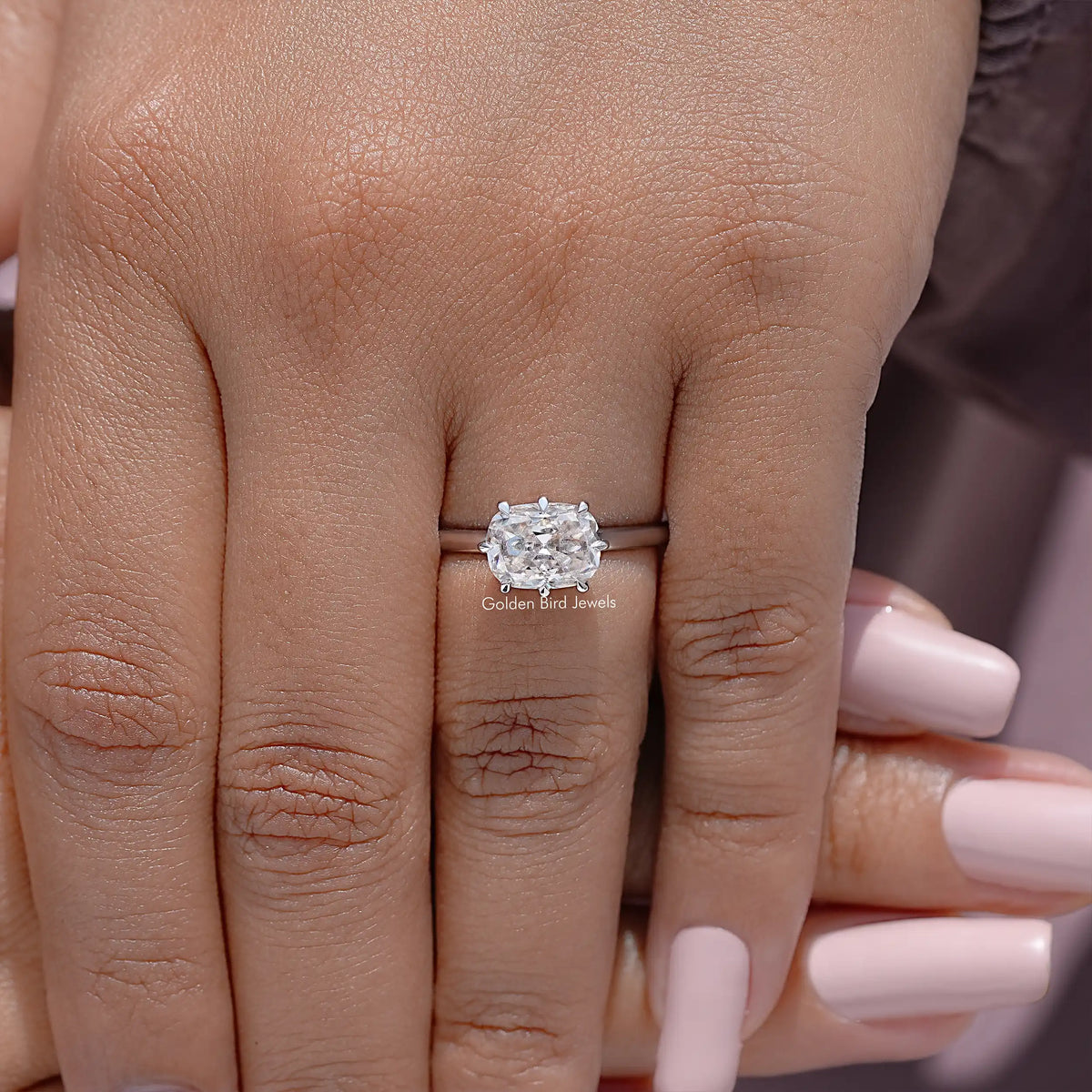 Silver cushion-cut moissanite ring on hand with slim band
