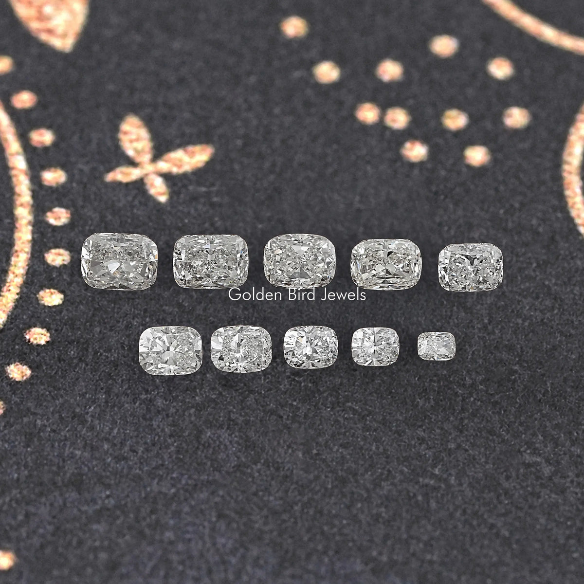 Set of elongated cushion lab-grown diamonds shown loose and assorted on dark felt.