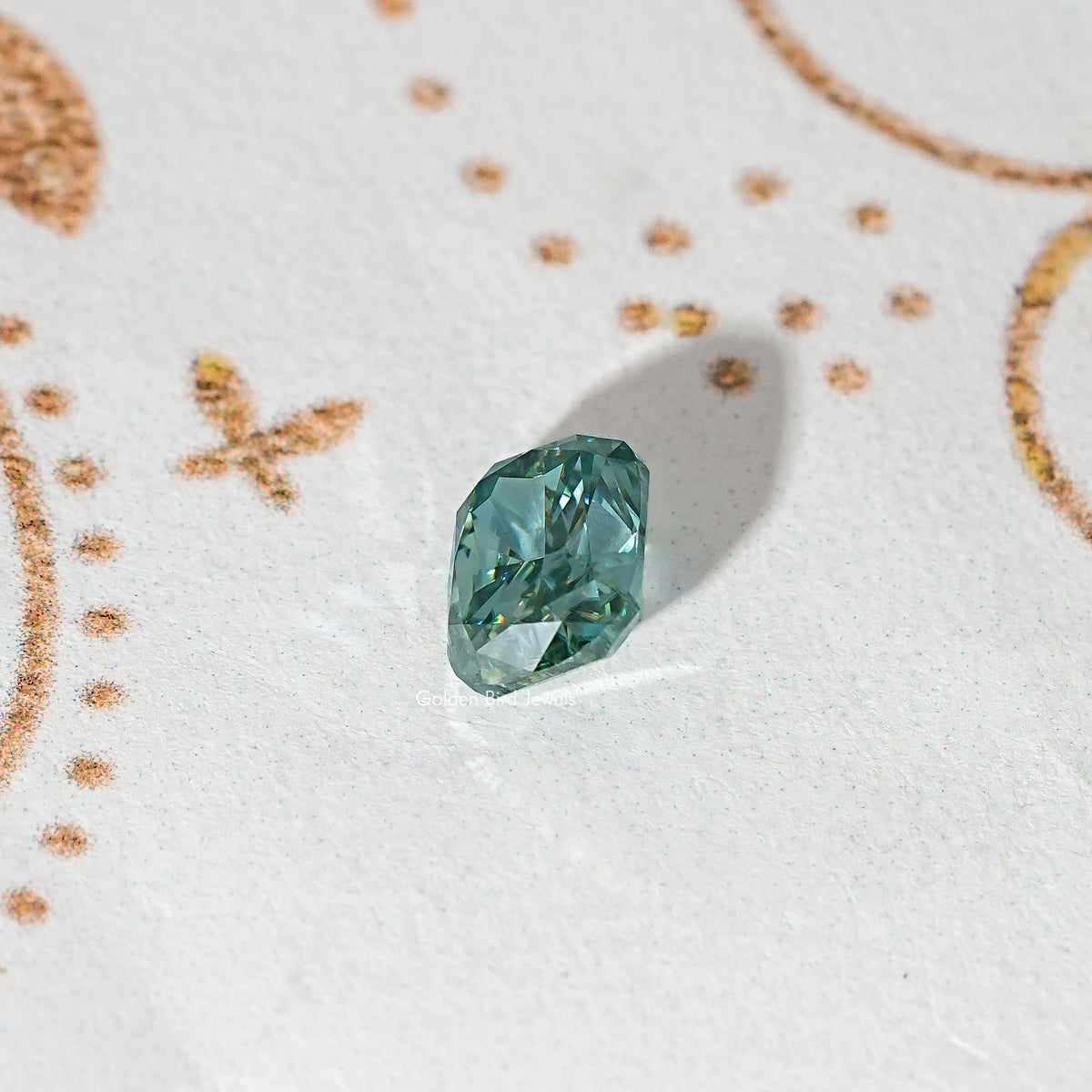 Elongated teal-green moissanite stone with prismatic faceting.