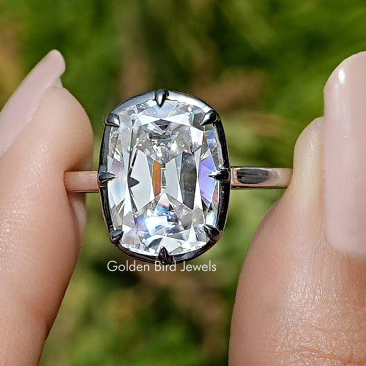 Front view of Moissanite Elongated Old Mine Cushion Cut Ring in two fingers 