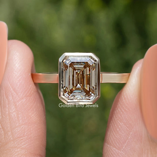 Rose-gold solitaire engagement ring with emerald-cut center stone, front view