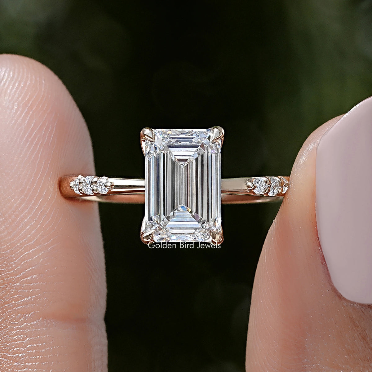 Emerald-cut lab diamond ring close-up with prongs and baguette-style side accents