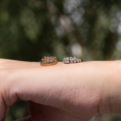 Gold-tone huggie hoop earrings with multi-shaped lab diamonds, side view on palm