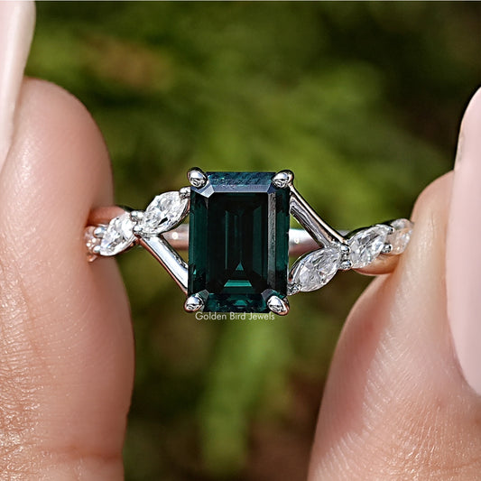 Sterling silver ring with green emerald-cut moissanite and floral side stones.
