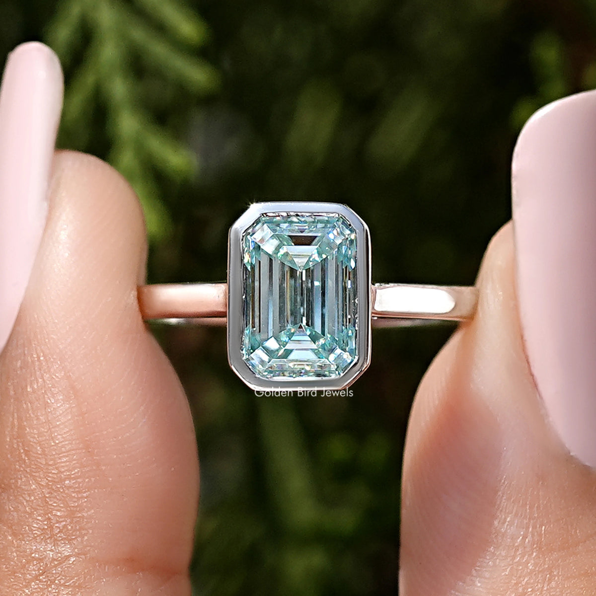 Front view of silver ring with emerald-cut blue moissanite in bezel setting