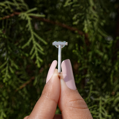Sterling silver solitaire ring with blue moissanite in emerald-cut bezel setting