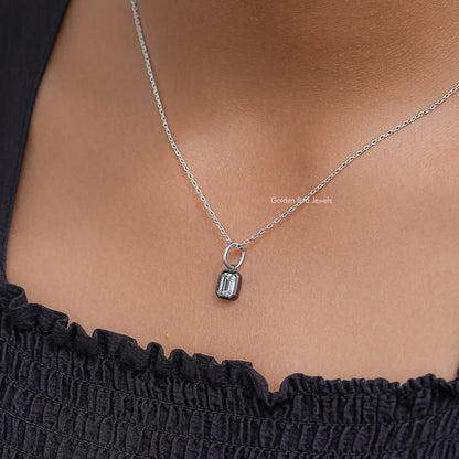 Rectangular solitaire pendant on thin silver chain over black ruffled top