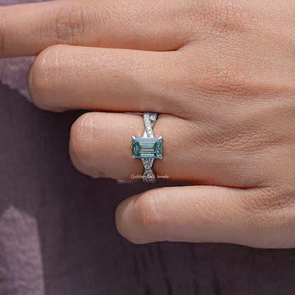 Teal emerald-cut moissanite wedding ring with twisted silver band, side view