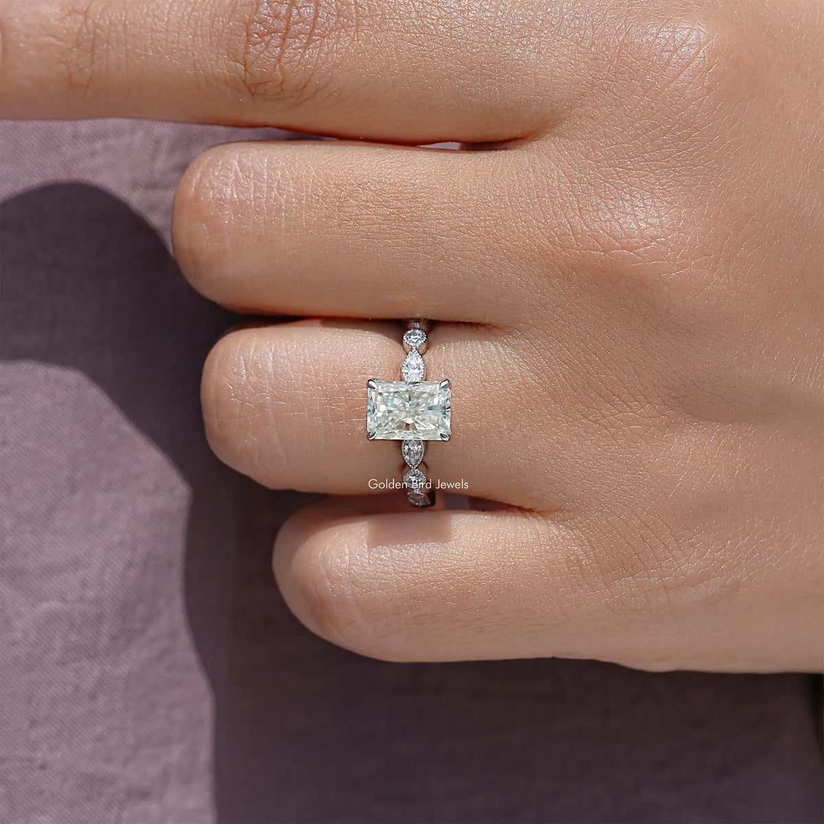 Radiant cut moissanite engagement ring with square center and side round stones on band
