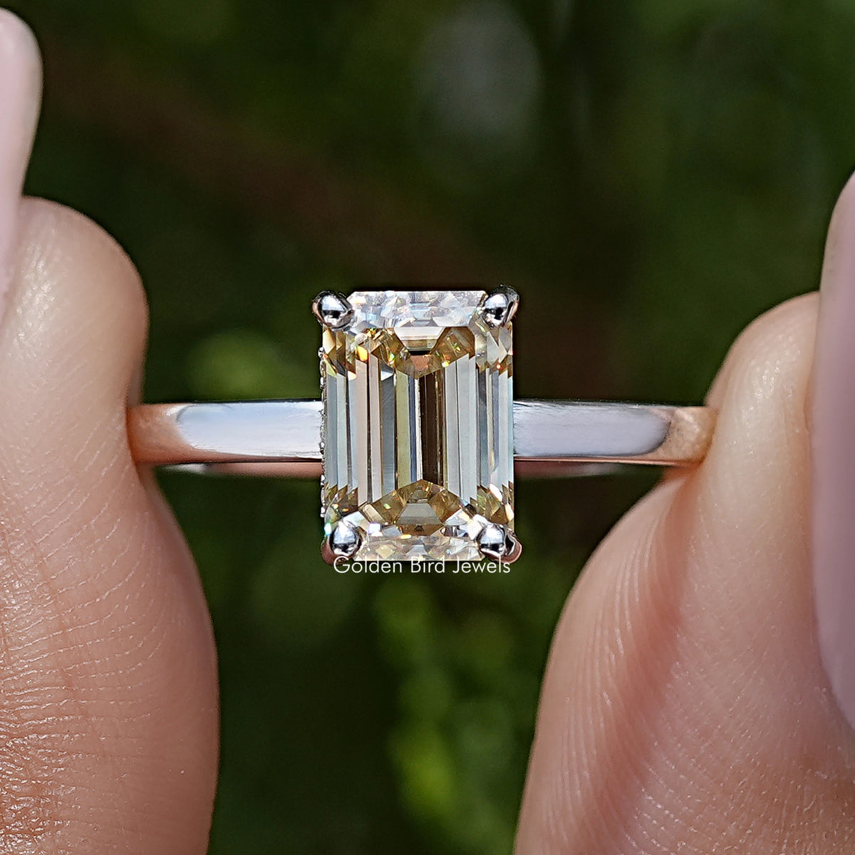 Macro view of yellow emerald-cut moissanite solitaire ring, sterling silver prongs