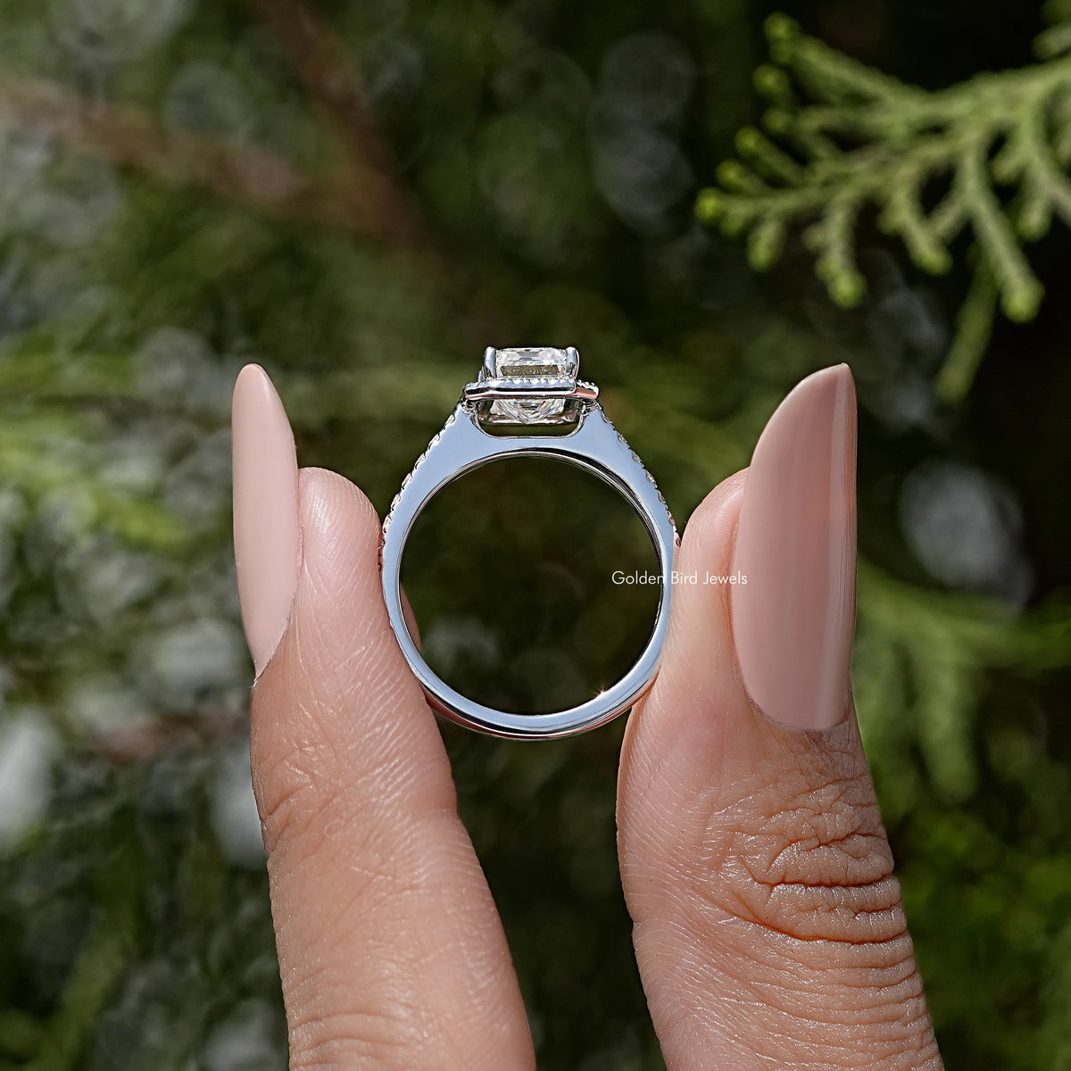 Sterling silver moissanite solitaire ring with round profile and emerald-cut center stone.