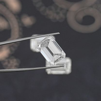 Emerald-cut lab diamond held between metal tweezers, clear faceted step design.
