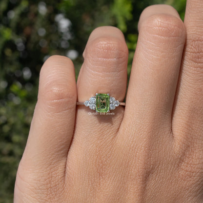 Silver ring with green square gemstone and sparkling side stones, on-finger view