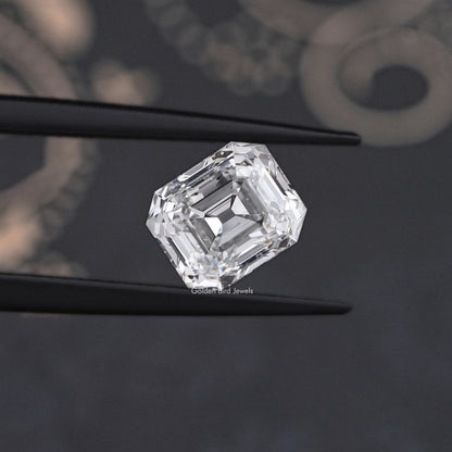 Emerald-cut lab-grown diamond in tweezers, cropped angled view