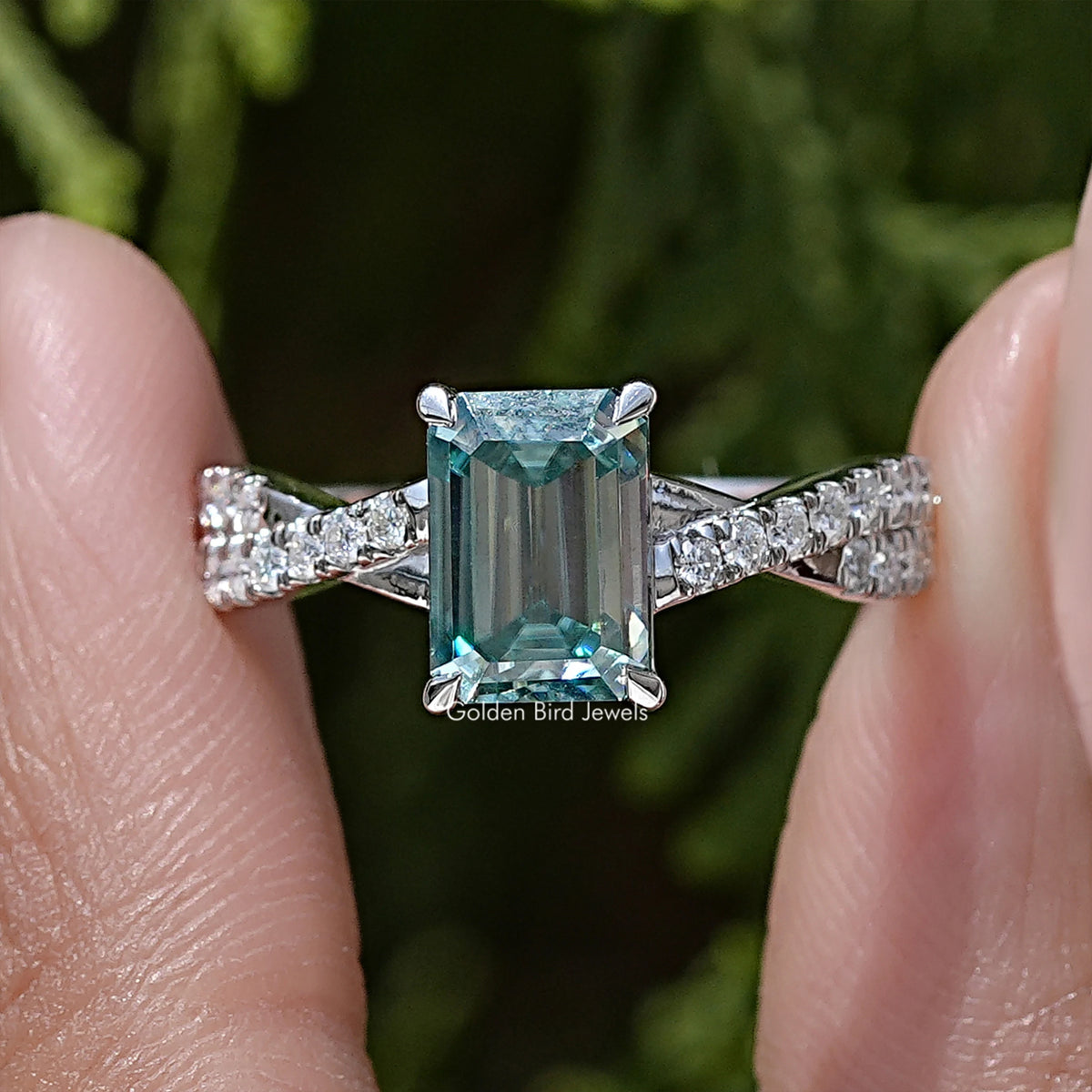 Emerald-cut moissanite twisted wedding ring with silver band and teal center stone