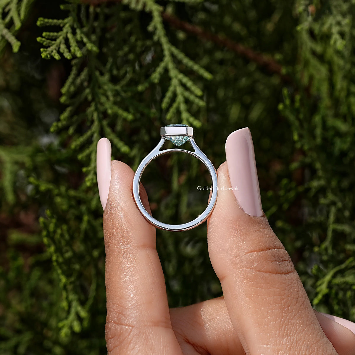 Sterling silver ring featuring an emerald-cut blue stone in a bezel setting