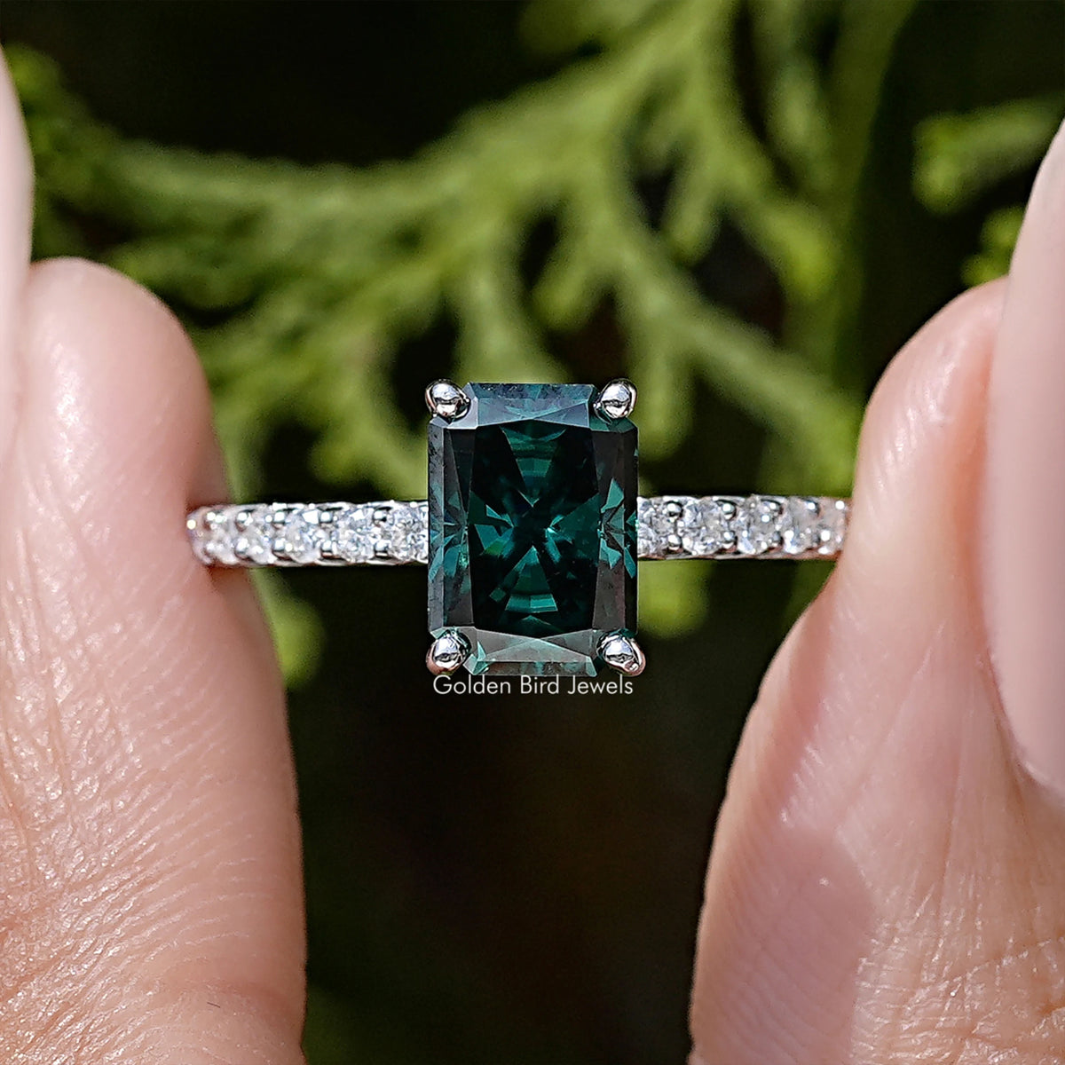 Detailed view: sterling silver ring with square green moissanite center and side baguette stones