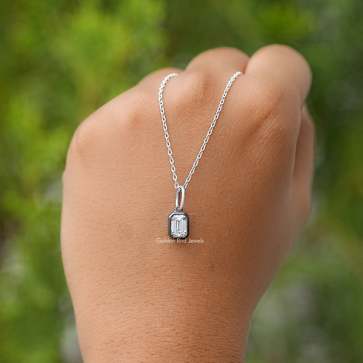 Rectangular solitaire pendant necklace on open hand
