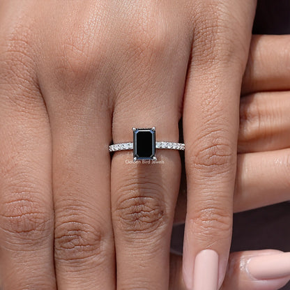 Black emerald-cut moissanite accent ring with a silver pavé band on a hand