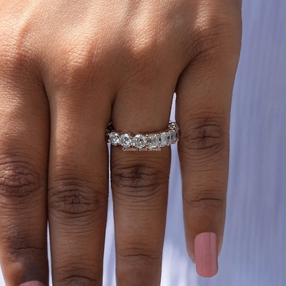 Round-cut moissanite band ring on hand, straight-on front view