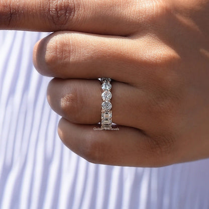 Moissanite round-stone band ring shown from the side on fingers